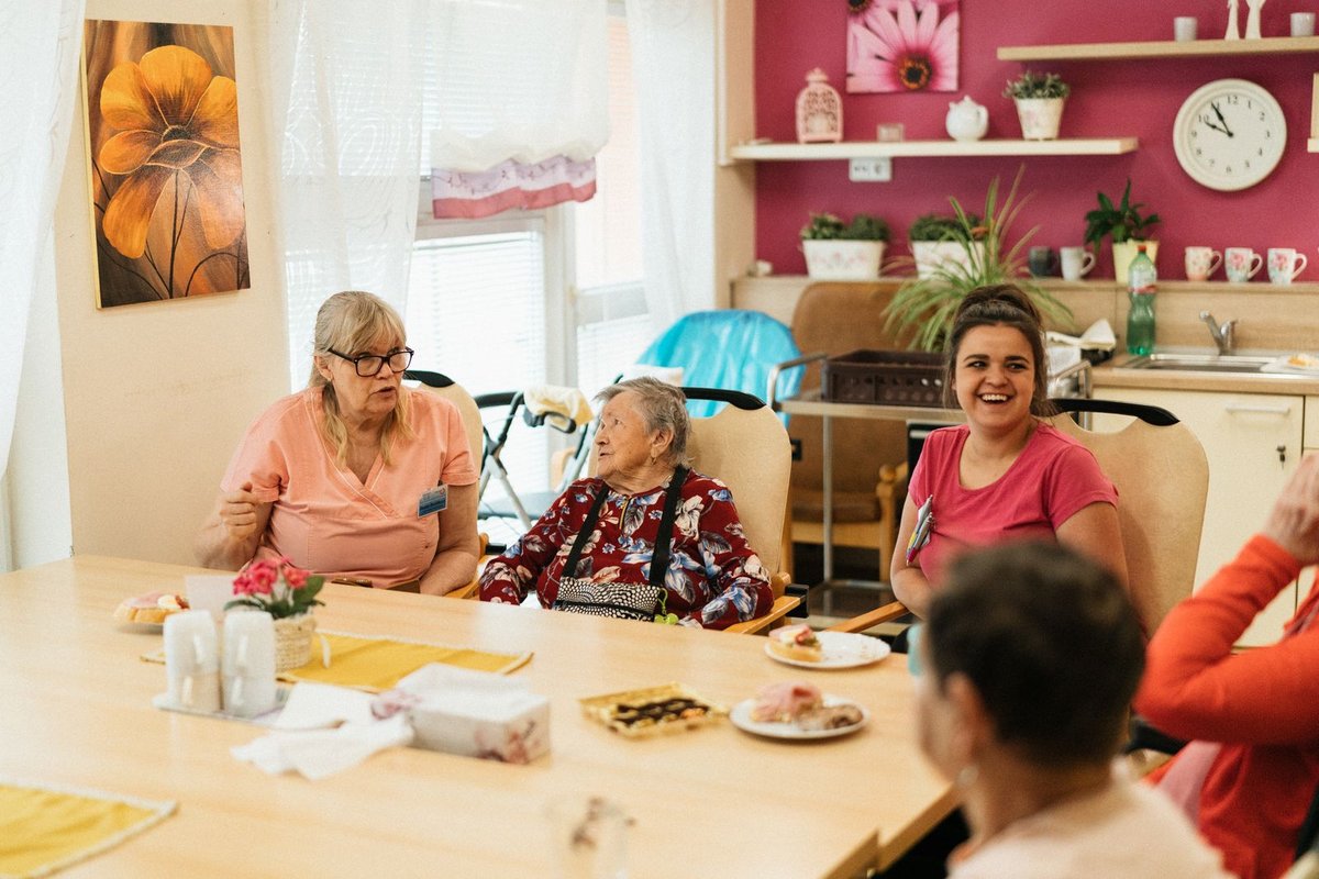 Residents and care staff sharing a meal in a senior living community